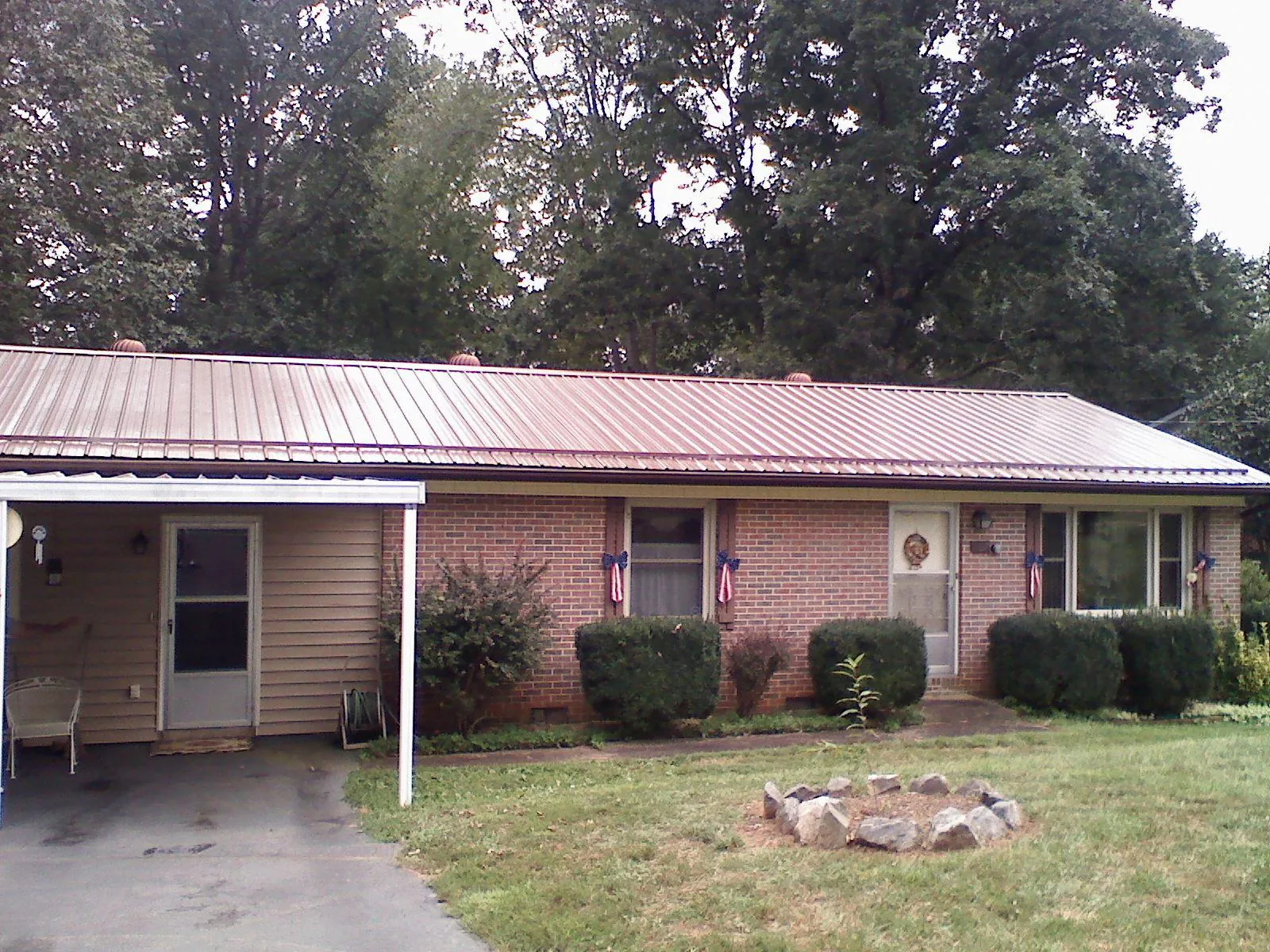 Bronze metal roof and carport on a brick ranch home — Roof Repair work by our crew in Otter Rock